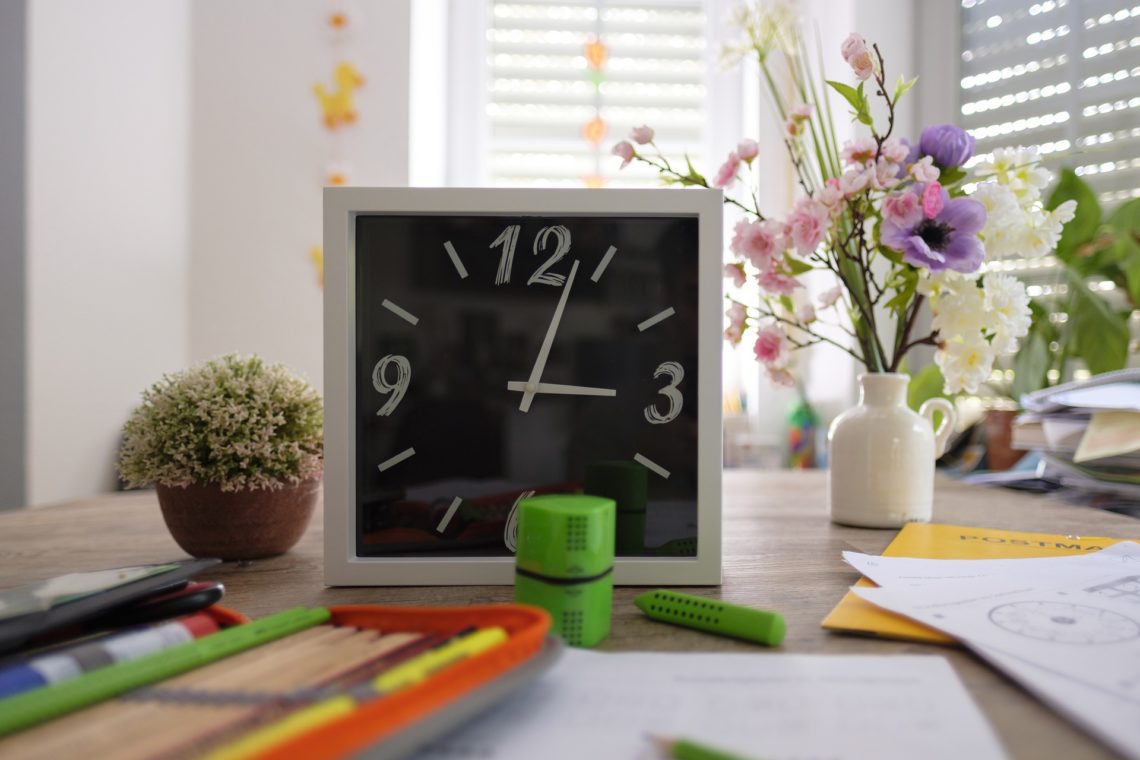 school desk with clock and supplies