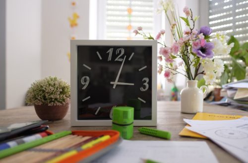 school desk with clock and supplies