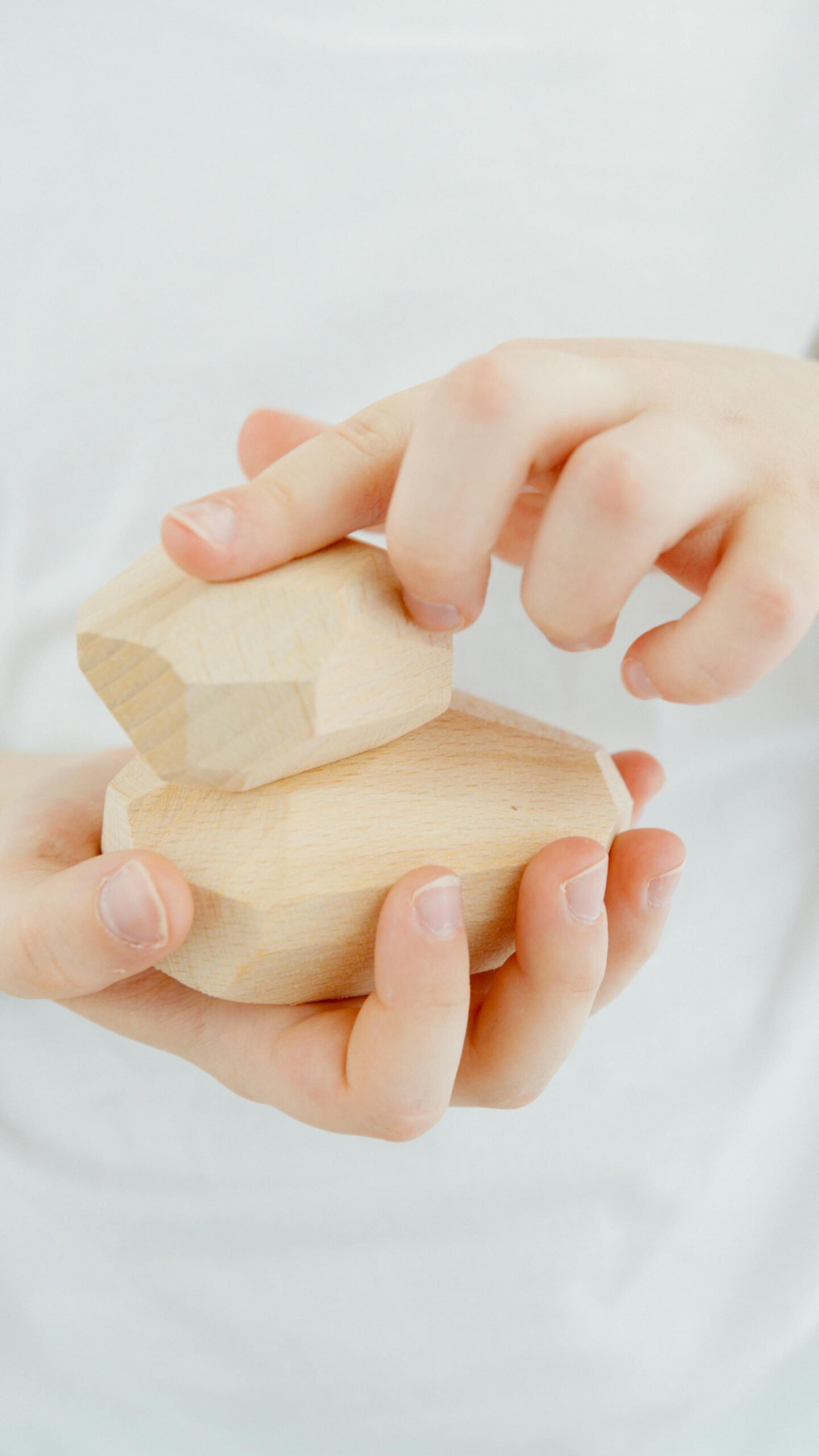 Child's hands playing with wooden toys