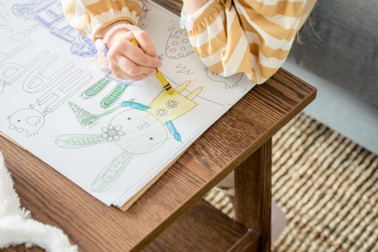 a child coloring on a coloring page on a table