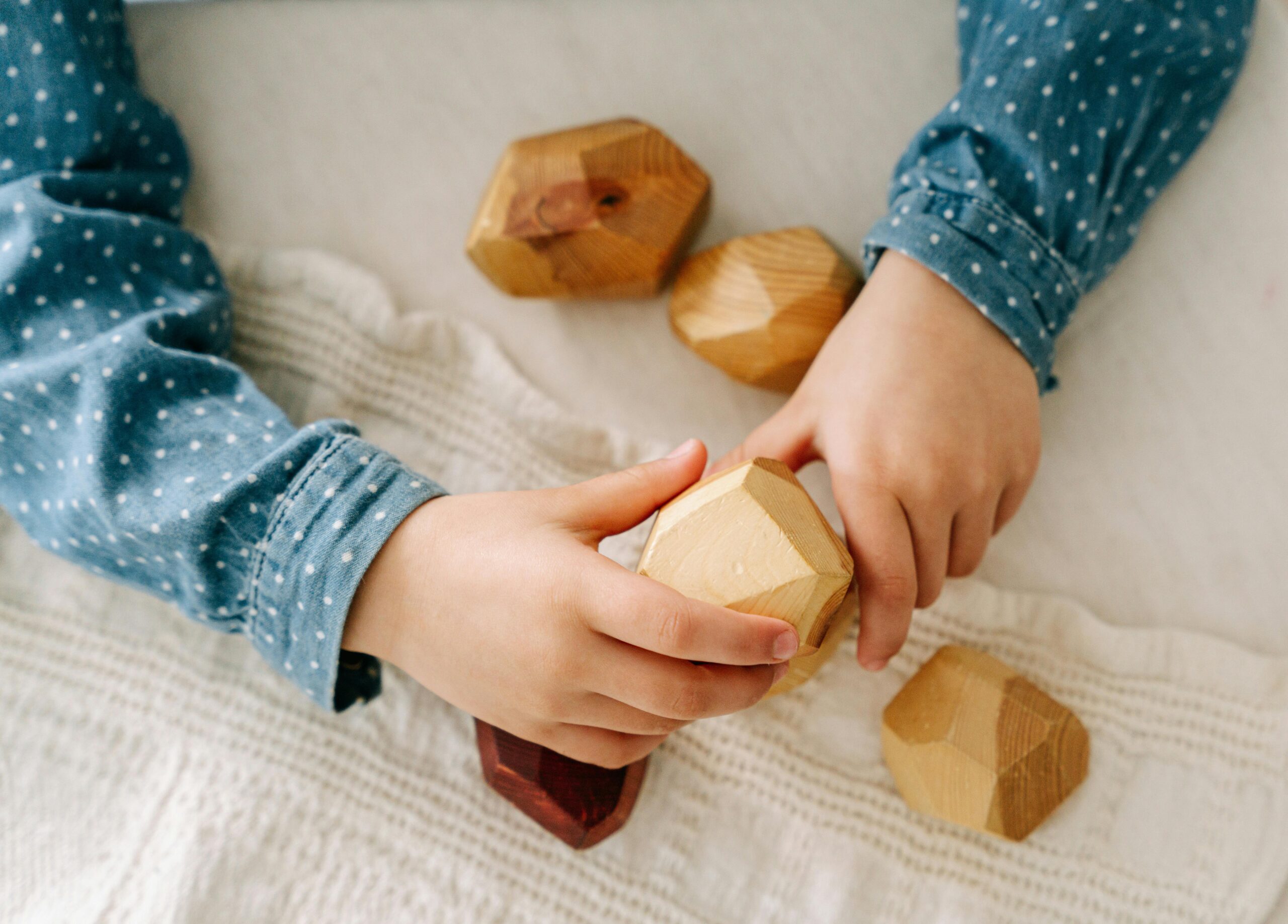 A child's hands playing with wooden toys